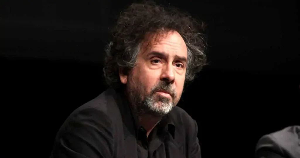 A thought-provoking image of director Tim Burton, surrounded by the iconic, surreal imagery from his films, sparking a conversation about alleged racial undertones in his cinematic works.