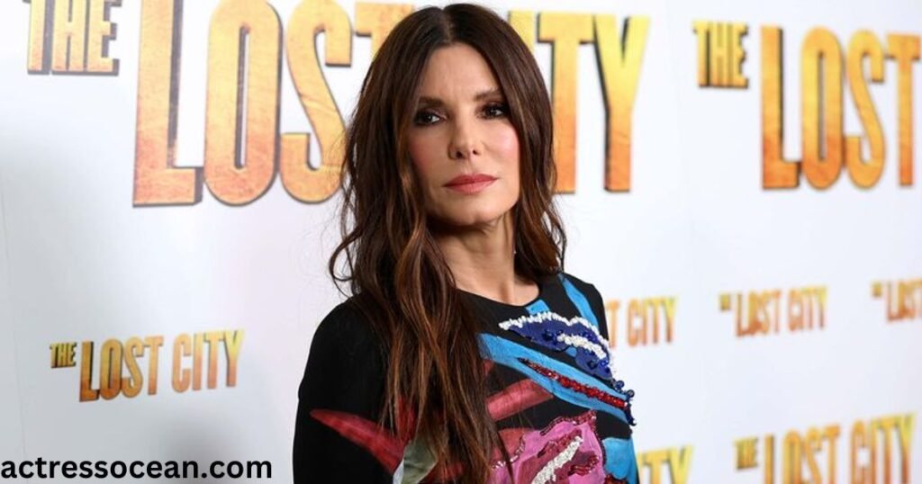 Sandra Bullock standing in front of a microphone, smiling.