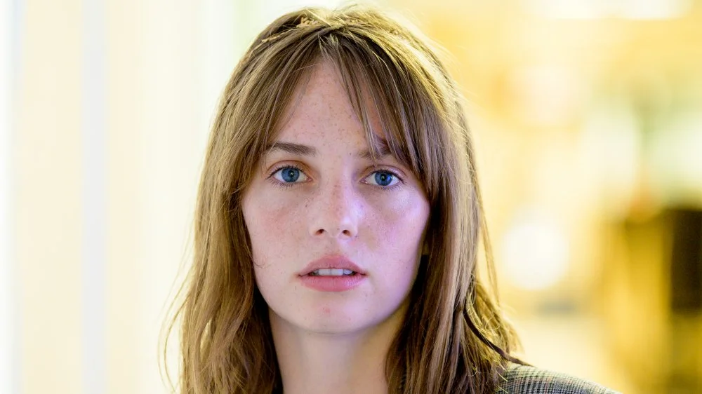 An image featuring Maya Hawke, daughter of Uma Thurman and Ethan Hawke, highlighting her family background in Hollywood and the legacy she's building in the entertainment industry.