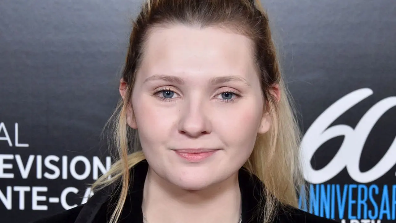 Image featuring Abigail Breslin with a text overlay showcasing 15 insightful and memorable quotes from her journey.